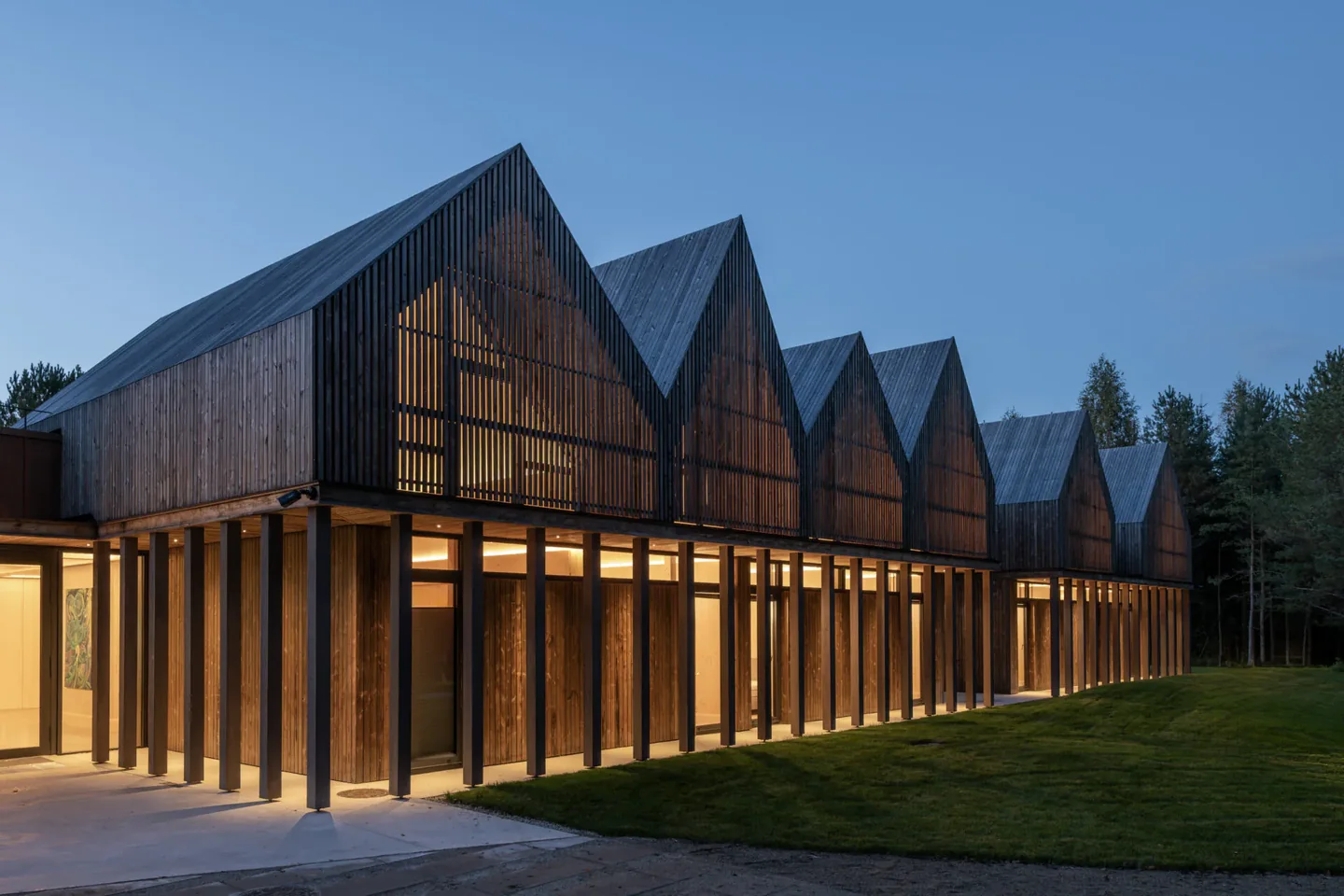Sanctum Nature medinės architektūros pastatas vakaro šviesoje
